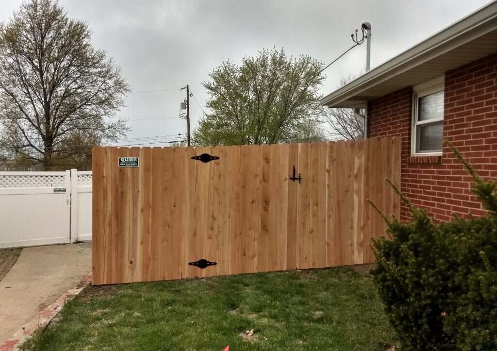 Wooden fence beside a brick house.