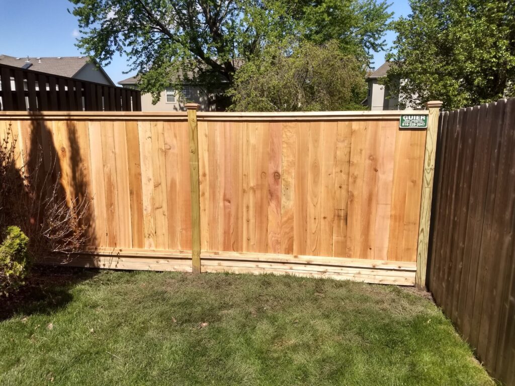Newly installed wooden fence panel in a backyard.